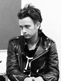 A Black And White Photo Of A Man Wearing A Black Leather Jacket GIF