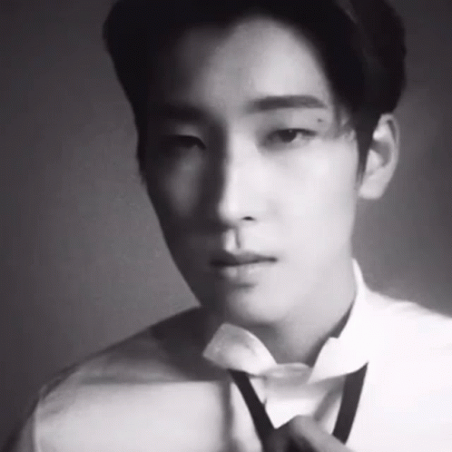 A Black And White Photo Of A Man Wearing A Bow Tie . GIF