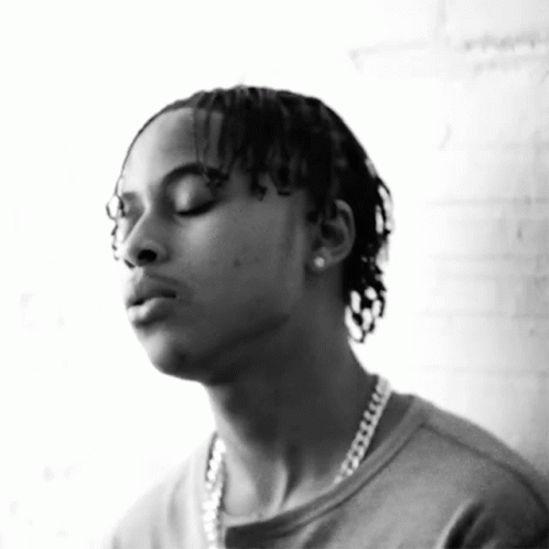 A Black And White Photo Of A Man Wearing A Chain Around His Neck GIF