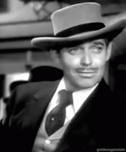 A Black And White Photo Of A Man Wearing A Hat And Tie GIF