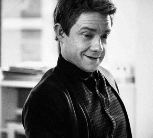 A Black And White Photo Of A Man Wearing A Plaid Shirt And Cardigan GIF