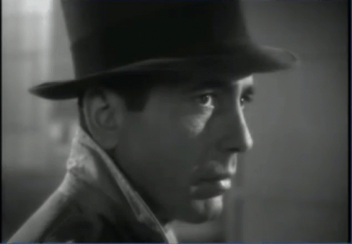 a black and white photo of a man wearing a top hat and coat