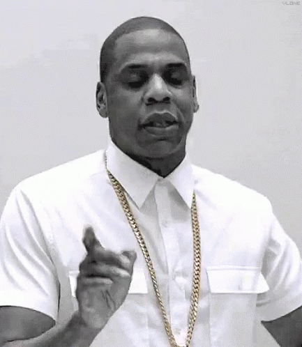 A Black And White Photo Of A Man Wearing A White Shirt And Gold Chain . GIF