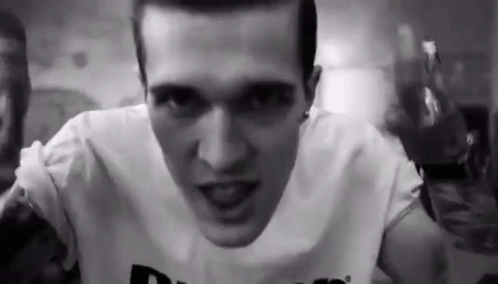 A Black And White Photo Of A Man Wearing A White Shirt . GIF
