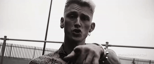 A Black And White Photo Of A Man Wearing Earrings And A Nose Ring . GIF