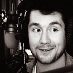 A Black And White Photo Of A Man Wearing Headphones And A Microphone GIF