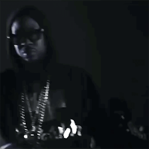 A Black And White Photo Of A Man Wearing Sunglasses And A Hood . GIF