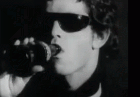 A Black And White Photo Of A Man Wearing Sunglasses And Holding A Coca Cola Bottle GIF