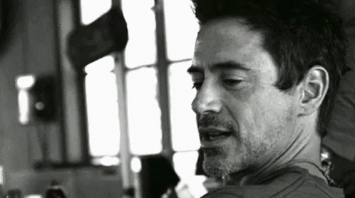 A Black And White Photo Of A Man With A Beard Looking At The Camera . GIF