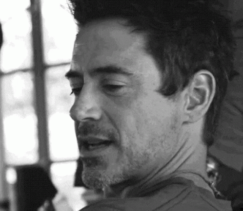 A Black And White Photo Of A Man With A Beard Looking At The Camera . GIF