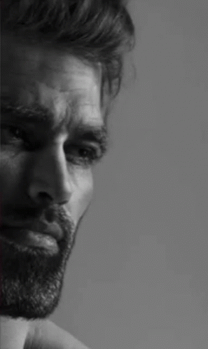 A Black And White Photo Of A Man With A Beard Looking Down . GIF