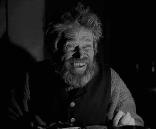 A Black And White Photo Of A Man With A Beard Smiling GIF