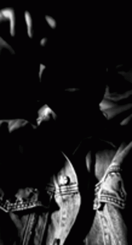 A Black And White Photo Of A Man With A Beard Wearing A Denim Jacket And Sunglasses . GIF