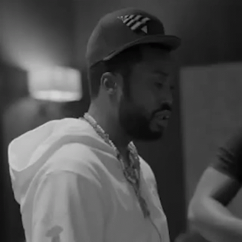 A Black And White Photo Of A Man With A Beard Wearing A Hat And Headphones . GIF