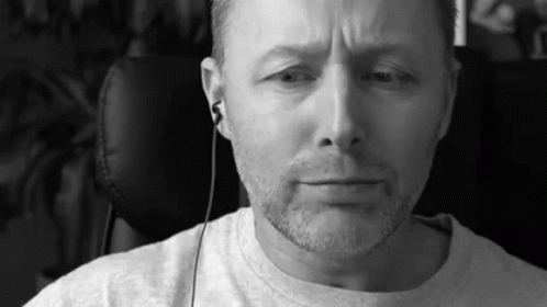 A Black And White Photo Of A Man With A Beard Wearing Headphones . GIF