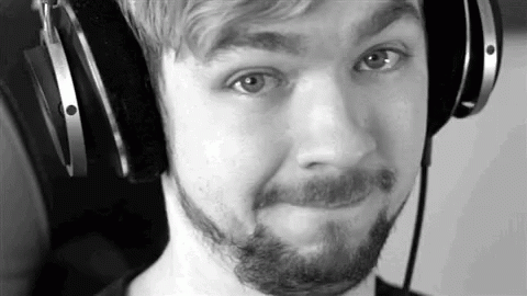 A Black And White Photo Of A Man With A Beard Wearing Headphones And Making A Funny Face . GIF
