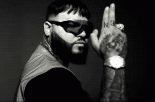 A Black And White Photo Of A Man With A Beard Wearing Sunglasses And A Watch GIF