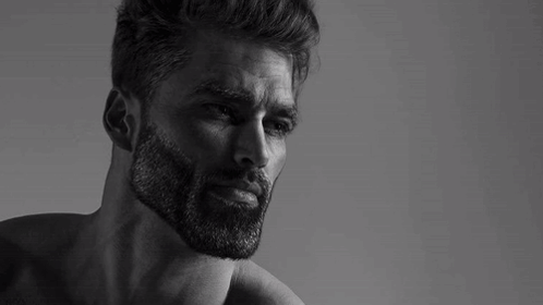 A Black And White Photo Of A Man With A Beard Without A Shirt On . GIF