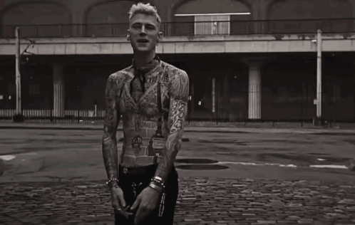 A Black And White Photo Of A Man With A Lot Of Tattoos On His Body GIF