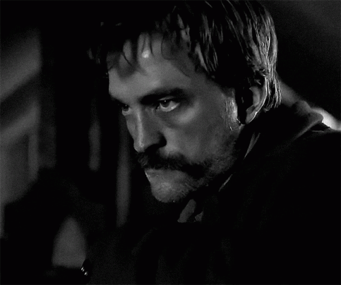 A Black And White Photo Of A Man With A Mustache And Beard GIF