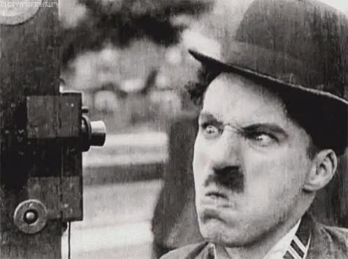 A Black And White Photo Of A Man With A Mustache Making A Funny Face GIF
