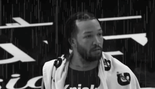 A Black And White Photo Of A Man With A Towel Wrapped Around His Neck . GIF