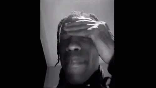 A Black And White Photo Of A Man With His Eyes Closed . GIF