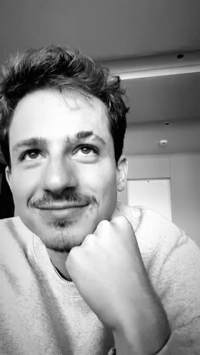 A Black And White Photo Of A Man With His Hand On His Chin Looking Up GIF