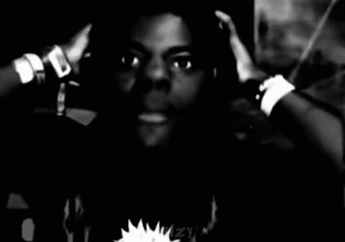 A Black And White Photo Of A Man With His Hands On His Head GIF