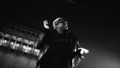 A Black And White Photo Of A Man With His Hands Together GIF