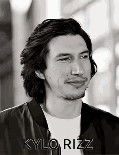 A Black And White Photo Of A Man With Long Hair And A Beard Wearing A Black Jacket . GIF