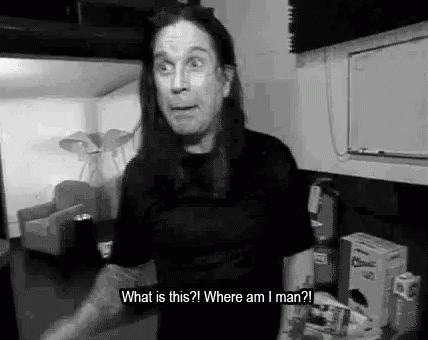 A Black And White Photo Of A Man With Long Hair Standing In A Room And Talking . GIF