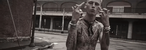 A Black And White Photo Of A Man With Tattoos Giving The Middle Finger . GIF