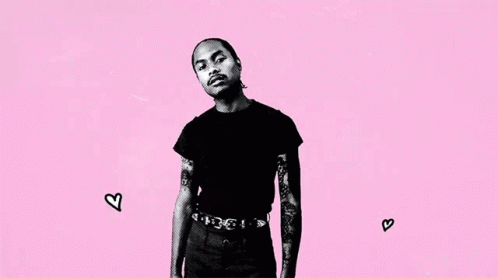 A Black And White Photo Of A Man With Tattoos On His Arms Standing On A Pink Background . GIF