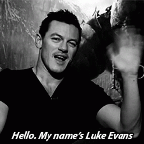 A Black And White Photo Of A Man With The Words Hello My Name 'S Luke Evans Below Him GIF