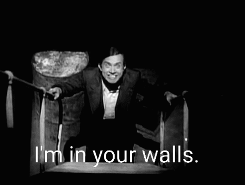 A Black And White Photo Of A Man With The Words I 'M In Your Walls Behind Him GIF