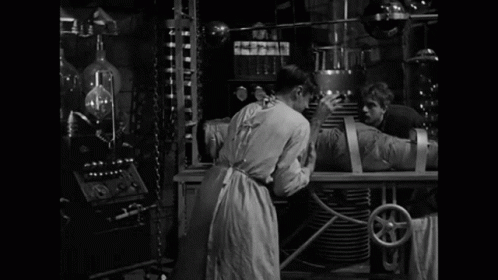 A Black And White Photo Of A Man With The Words It 'S Alive Behind Him GIF