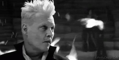 A Black And White Photo Of A Man With White Hair And A Mohawk . GIF