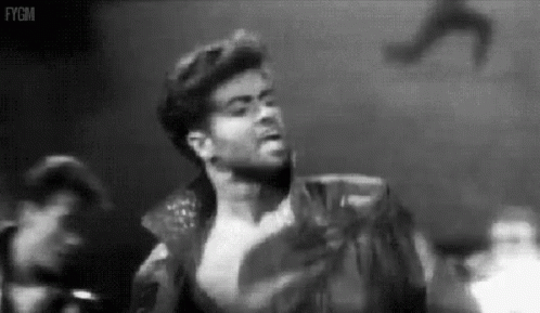 A Black And White Photo Of A Man Without A Shirt On A Stage . GIF