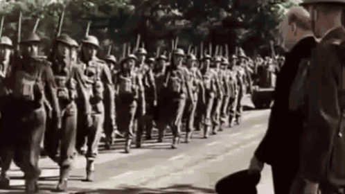 A Black And White Photo Of A Military Parade With A Man Standing In The Foreground . GIF