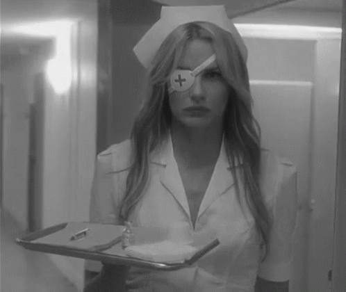 A Black And White Photo Of A Nurse Holding A Tray With A Cross On Her Eye . GIF
