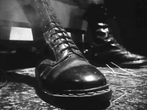 A Black And White Photo Of A Pair Of Boots GIF