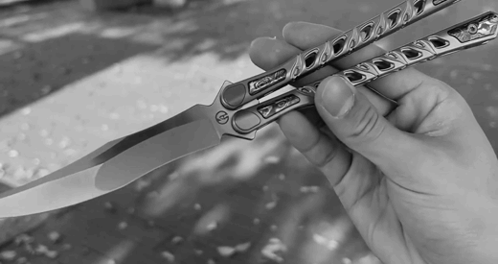 a black and white photo of a person holding a knife with the word xtreme on it