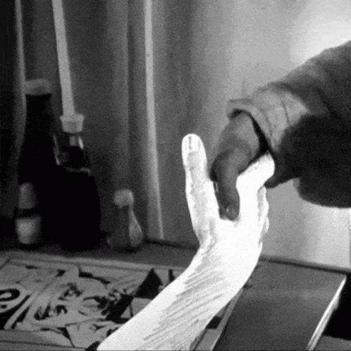 A Black And White Photo Of A Person Holding A Piece Of Paper GIF