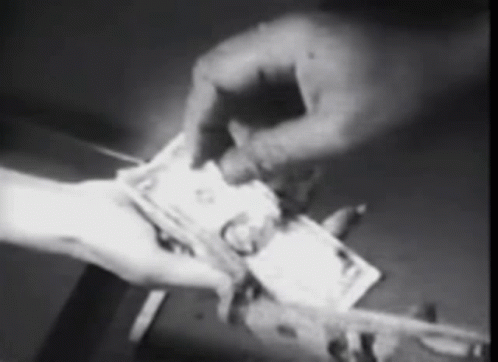 A Black And White Photo Of A Person Holding A Stack Of Money . GIF