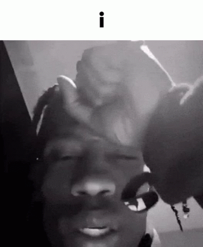 A Black And White Photo Of A Person Holding Another Person 'S Hand On Their Forehead . GIF