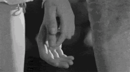 A Black And White Photo Of A Person Holding Another Person 'S Hands . GIF