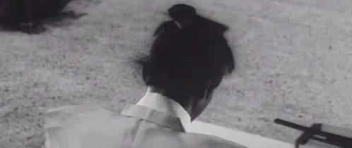 A Black And White Photo Of A Person Laying On The Ground With A Shadow On The Ground . GIF