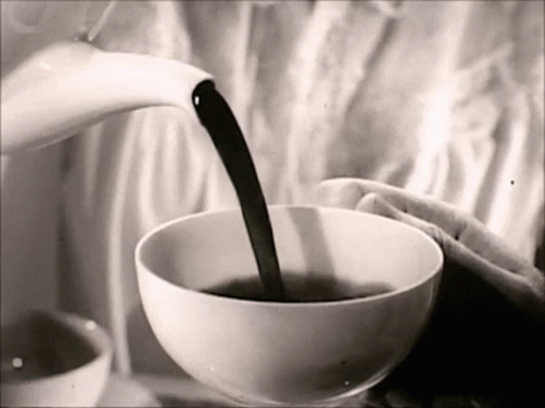 A Black And White Photo Of A Person Pouring A Cup Of Coffee GIF