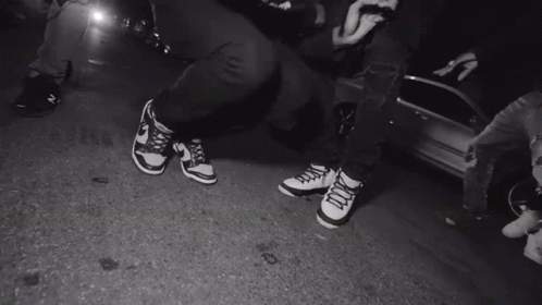 A Black And White Photo Of A Person 'S Feet Wearing Nike Shoes GIF